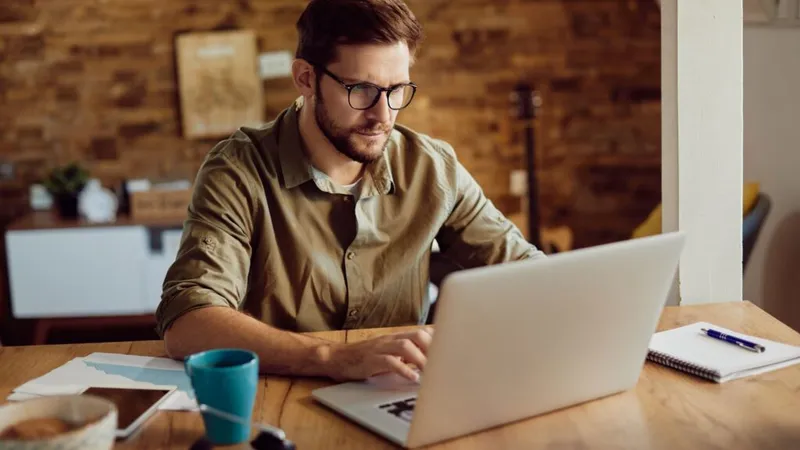 man deleting a comment on Instagram using a laptop