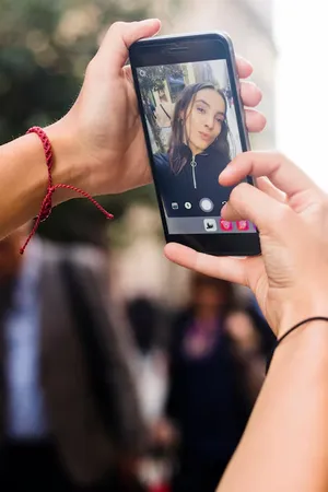 Person watching a live video on a mobile phone Person watching a live video on a mobile phone