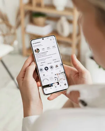 A young woman is looking at an Instagram profile on her smartphone,. A young woman is looking at an Instagram profile on her smartphone,.