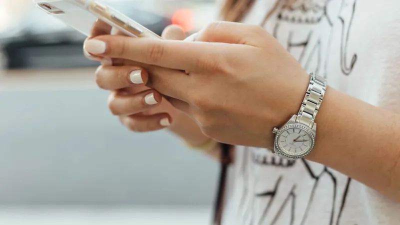 A young woman holding a phone.