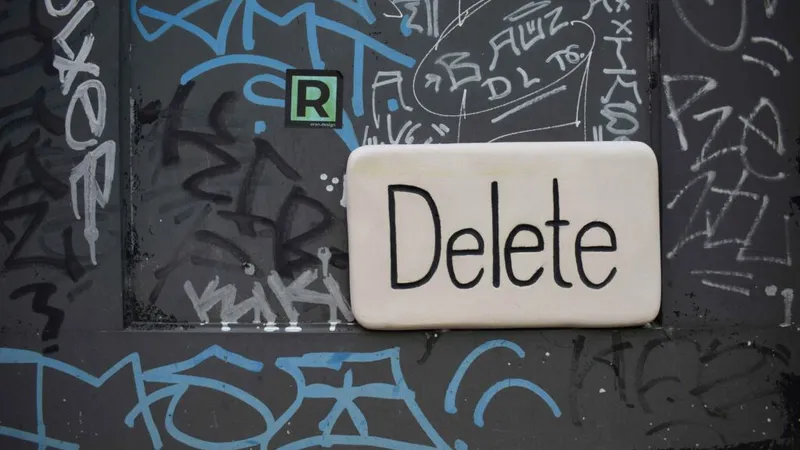 The word 'Delete' written on a graffiti-covered wall