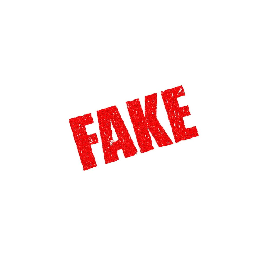 Red word 'FAKE' written on a white wall