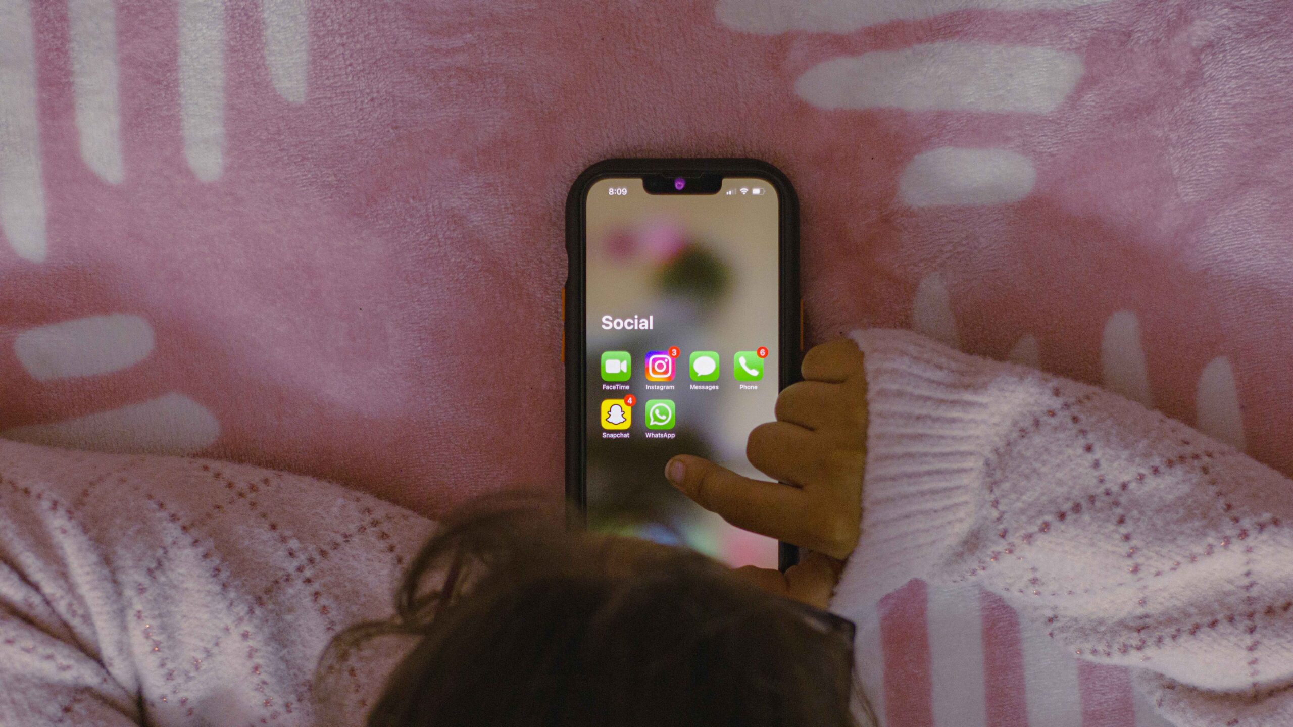 Girl looking at her phone, checking Instagram app with new notification on the screen.