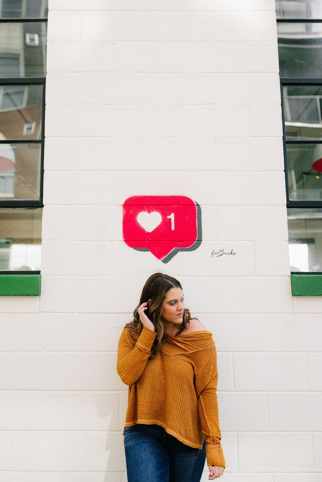 A young woman standing with the Instagram like symbol above her head